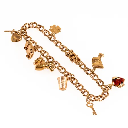 Armband, Bismarck i 18K guld med åtta berlocker: Fingerborg, bil, nyckel. Det är 20 cm långt, 5,3 mm brett och väger 16,3g. Kistlås. 