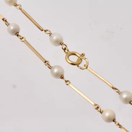 Kedja i 18K guld, 43,5cm, bredd 0,95mm, 17st odlade pärlor, mått Ø4,8mm, bruttovikt 6,06g, ca nettovikt 2g.