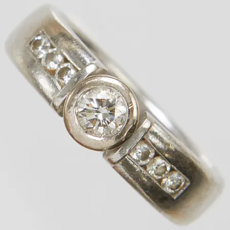 Enstensring med diamanter 1 x ca.0,35ct, ca.TCr(I)/VS samt 6 x ca.0,03ct, Ø19¾, bredd: 5,9-6,5mm, personlig gravyr, repor, litet hack på insidan av skenan, svenska stämplar, vitguld, 18K Vikt: 12,4 g