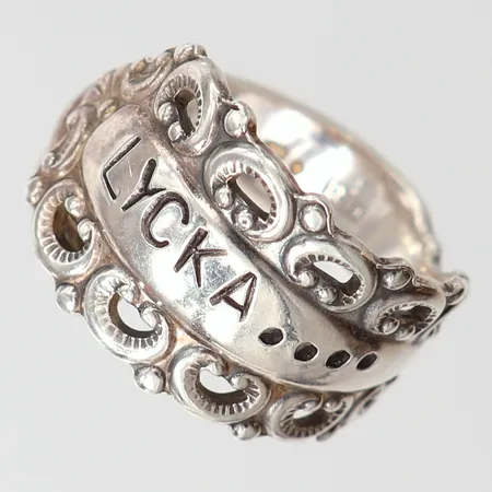 Ring med text "Lycka", stl 18½, bredd 5,5-14,5mm, reglerbar skena. 830/1000 silver Vikt: 6,6 g