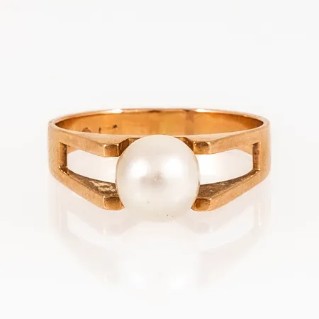 Ring i 18K guld med odlad pärla Ø 7 mm. Den är i storlek 17¼, är 3 - 7 mm bred och väger 3,3g. Stämplad ALTON, 18K & kattfot. Spricka i pärla.