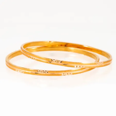 Två armringar i 21K guld med mönsterdekor. De är 3 mm breda, har en innerdiameter på 54 mm och väger 9,7g. Ihåliga. OBS! Mycket liten storlek!