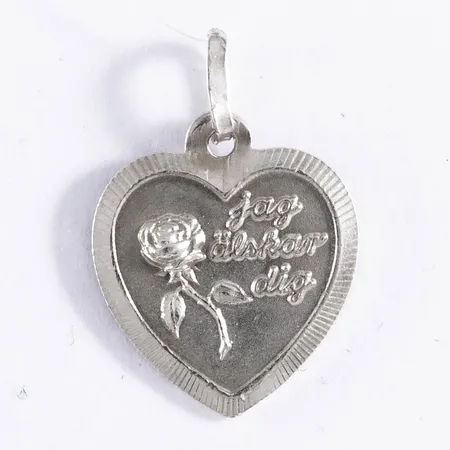 Hänge i silver (925/1000): Hjärta med rosmotiv och texten "jag älskar dig". Det är 14,5 mm brett, 21 mm långt inkl. ögla och väger 1,4g.