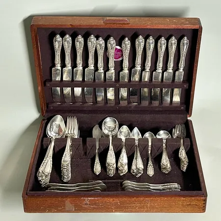 Schatull med silverbestick, 12 matknivar med stålblad, 12 matskedar, 12 bordsskedar, 12 Dessertskedar, 10 skedar med spets, 12 mindre skedar, 12 smörknivar, 11 dessertgafflar, 3 serveringsbestick, samtliga med monogram, gravyr årtal 1917, sterlingsilver 925/1000 Vikt: 4348,5 g