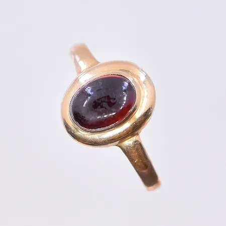 Ring med röd sten, stl 16¼, bredd 2-10 mm, något skev skena, 18K. Vikt: 1,6 g