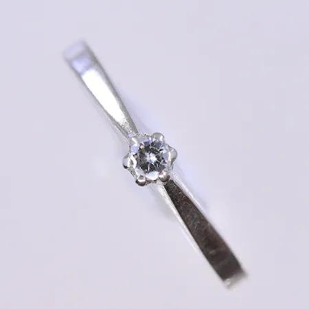 Ring med diamant 0,07ctv enligt gravyr, stl 18, bredd 2 mm, vitguld, 18K. Vikt: 2,2 g