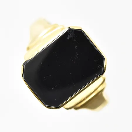 Klackring med onyxplatta, stl 21¼, bredd 3-15 mm, repig sten, ojämn/skev skena, 18K. Vikt: 5,7 g