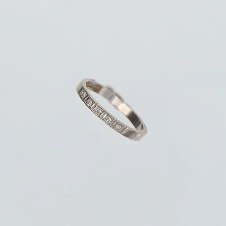 Ring med briljantslipade diamanter totalt 0,05ctv enligt gravyr, stl: 18, bredd 2,5mm, vitguld 18K.  Vikt: 2,7 g