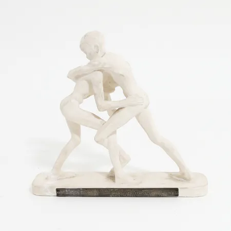 Skulptur i gips av Stig Blomberg "Tampande pojkar", höjd: 18cm, längd: 18,5cm, lagning på sockel och över pojkes fot, lös bricka i silver med gravyr.