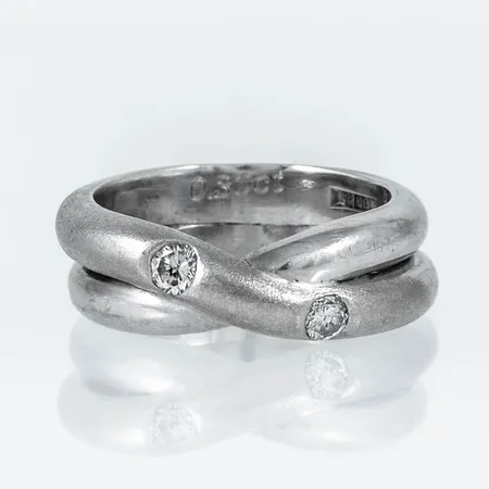 Ring i 18K vitguld: Delvis matterad med 2 x c:a 0,15ct (c:a W/Pique) briljantslipade diamanter. Den är i storlek 18¾, är 4,5 - 8 mm bred och väger 16,2g. Stenstorlek 0,30ct ingraverat. Stämplad OG (Odenguld AB, Köping), 18K.