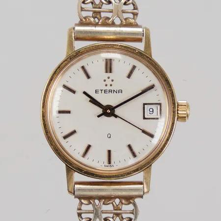 Damur Eterna Q, boett 18K, Ø ca 22mm, datum, quartz batteribyte krävs, gravyr, integrerat armband Silver, X-länk med stav, svag förgyllning, total längd inkl ur ca 16,5cm, bredd ca 10mm, 18K samt Silver 830/1000, bruttovikt 19,2g