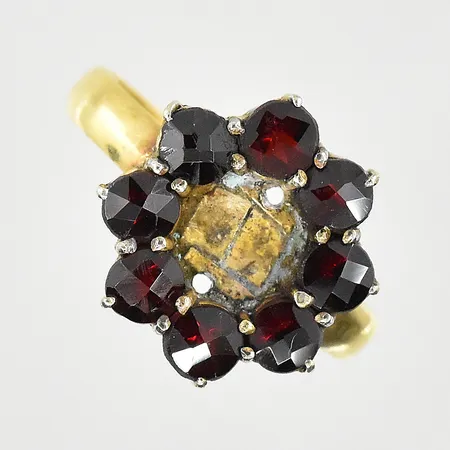 Ring med granater, stl 17¾, bredd 3-13 mm, gravyr, mittsten saknas, ojämn skena, ovandel i metall, 23K. Vikt: 2,9 g