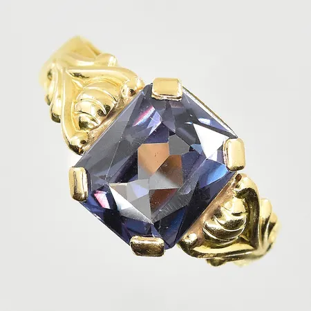 Ring med lila sten, stl 19, bredd 5-11 mm, gravyr, ojämn skena, 23K. Vikt: 7,3 g