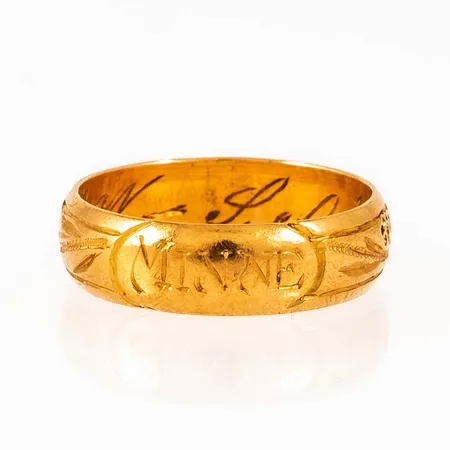 Ring i 23K guld med mönstergravyr och utvändig gravyr "Minne". Den är i storlek 17½, är mm bred och väger 5,0g. Stämplad K7 (1912), E.SÖDERBERG (Erik Söderberg, Sunne), 23K & kattfot. Invändig gravyr.