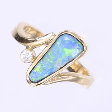 Ring med skimrande sten troligen opal samt syntetisk diamant 1x ca 0,05ct, stl 18, bredd 3-15mm, design Rebecca Falck, nagg på opal, 14K bruttovikt 5,7g Vikt: 5,7 g