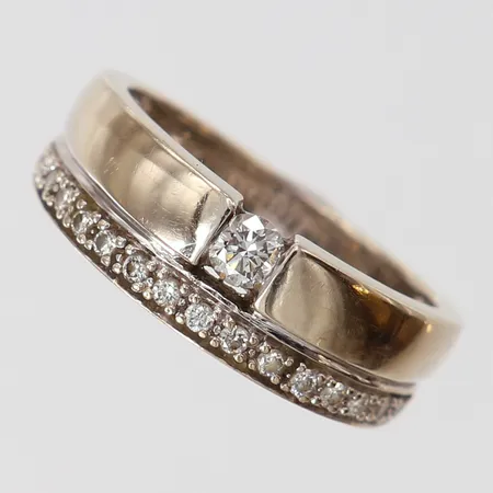 Ring med briljantslipade diamanter 1 x ca 0,15ct, 15 x ca 0,01ct, stl: 17½, bredd 4,5-6,5mm, GHA, behov av omrodiering, vitguld 18K.  Vikt: 6 g