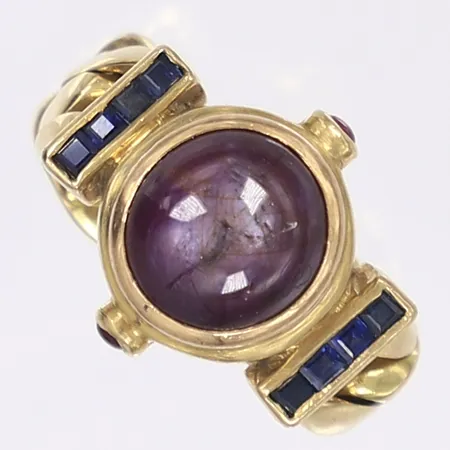 Ring med cabochonslipad stjärnrubin och små trappslipade safirer, ledad skena tillverkad från pansarkedja, stl 17¼, bredd 7-15mm, stämplad "adler", ingen karathaltstämpel, 18K Vikt: 13,1 g