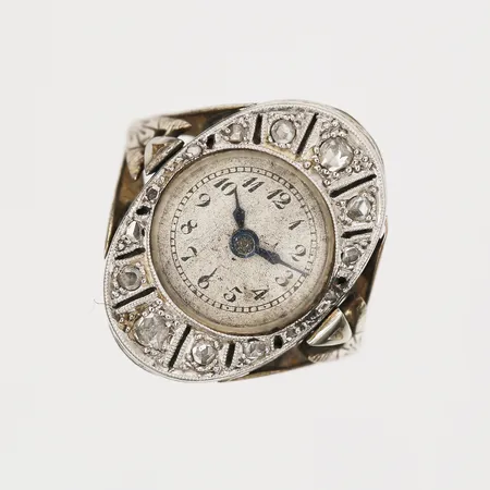 Ring med ur, Art déco, med rosenstenar, manuellt urverk, ca 20x14mm, fattning av silver, slitage, missfärgad urtavla, bucklor och märken, 18K vitguld, bruttovikt 8,4g