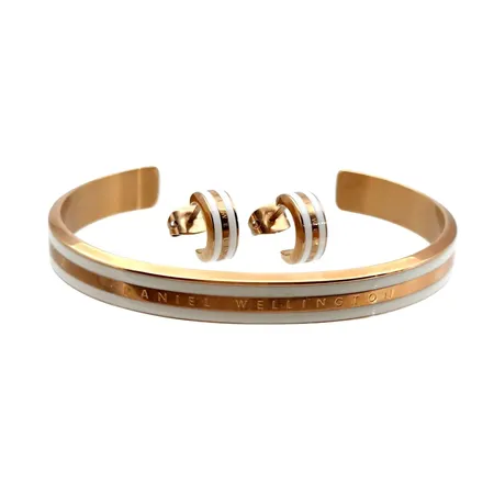 Armring & Örhängen, ett par, Daniel Wellington, förgylld metall, armring inre mått 15,5 cm, bredd 7 mm, örhängen längd 10 mm, bredd 4,5 mm, förefaller sparsamt använda