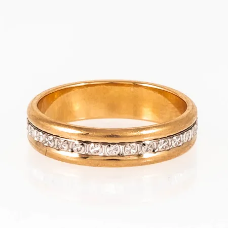 Mönstrad ring i 18K röd- och vitguld. Den är i storlek 16½, är 4,5 mm bred, 1,4 mm hög och väger 4,4g. Stämplad FU (Flemming Uziel AB, Helsingborg), 18K.