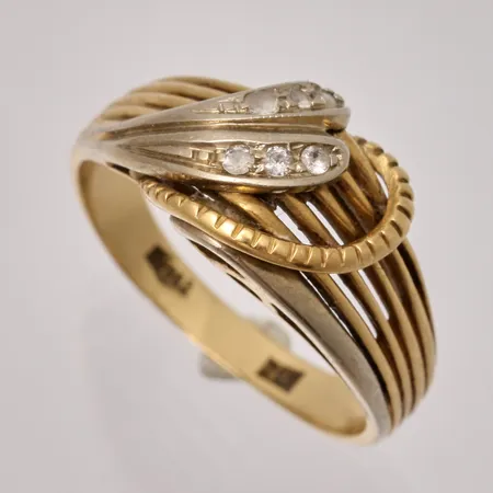 Ring i 18K guld, stl 17½, bredd 2,7-10,4mm, 6st vita stenar infattade i vitguld, skev i skenan, vikt 4,85g.