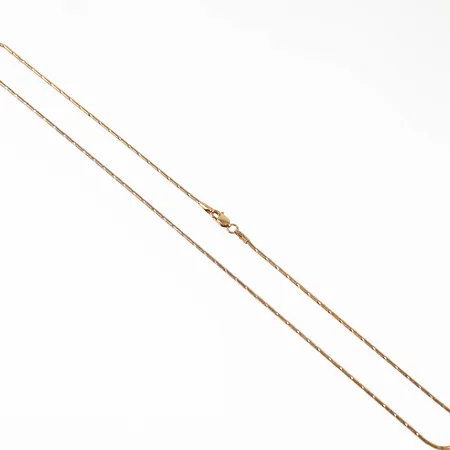 Kedja i 14K guld. Ormlänk med vitguldsdetaljer. Den är 42 cm lång, 1,2 mm bred och väger 5,0g. Karbinhake. 