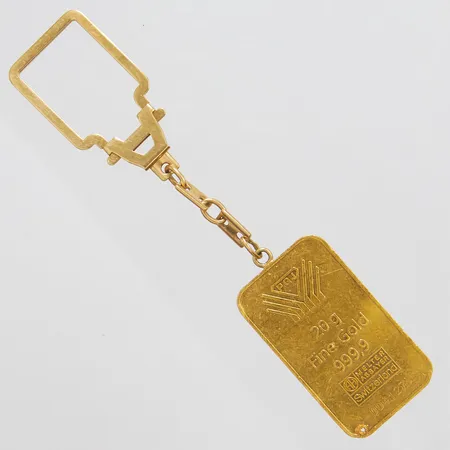 Nyckelring/tacka, längd med kedja 11cm, tacka ca 40x23,2mm, Melter Assayer Switzerland, fine gold 999,9, 20g, borrhål, repig, nyckelring i 18K, 24K, bruttovikt: 25,9g.