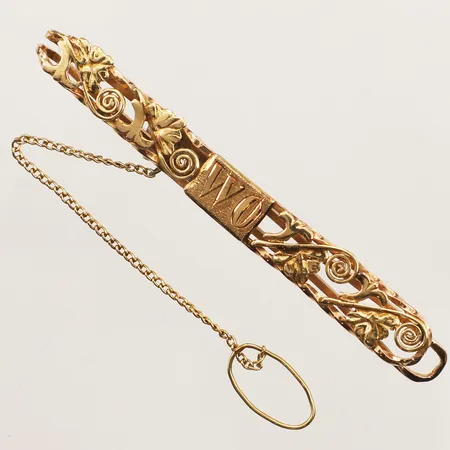 Sliphållare, längd 65mm, bredd 7,7mm, monogramgravyr, 18K  Vikt: 7 g