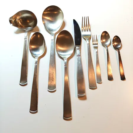 9 knivar 583gr brutto, 1 slev 7,5cm, 1 större sked 11cm, 9 bordsgafflar 18cm, 8 bordsskedar 18cm, 1 matsked 18,5cm 9 mockaskedar 11cm, 7 kaffeskedar 12cm, 4 desertgafflar, 12cm, 1070g modell Rosenholm   