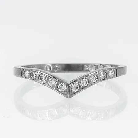 Ring i 18K vitguld med 10 x 0,01ct briljantslipade diamanter. Den är i storlek 16½, är mm bred och väger 1,9g. Stenstorlek 0,10ct ingraverad. Stämplad Q10 (1990, EN (Erik A. Nilson & Co), 18K & kattfot.