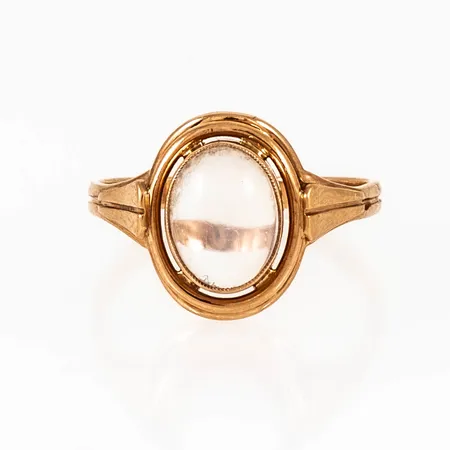 Ring i 18K guld med en cabochonslipad sten (ev. månsten). Den är i storlek 17½, är 2 - 13 mm bred och väger 3,1g.