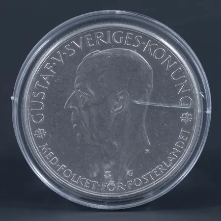 Jubileumsmynt GUSTAF V 1935 / 5 KRONOR i plastetui. Ø 36 mm.  Silver 900/1000. 25g.