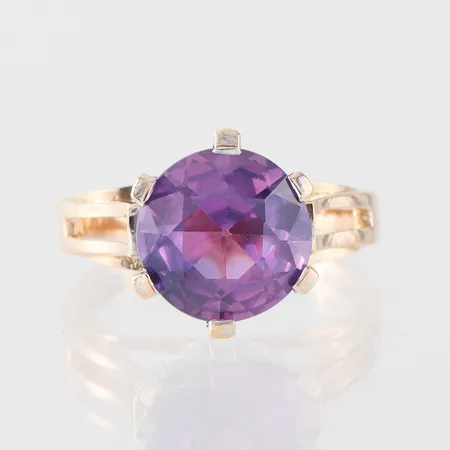 Ring med lila sten, MGAB Uppsala, storlek 16 mm, bredd 2.3-10.8 mm, 18k. Vikt: 5,3 g