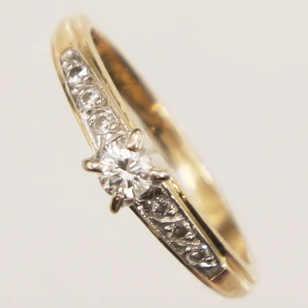 Ring med diamanter 1x ca 0,10ct indikerar på syntetisk, 6x ca 0,01ct, stl 15, bredd 1,5-3,8mm, skeva klor, 14K  Vikt: 2 g