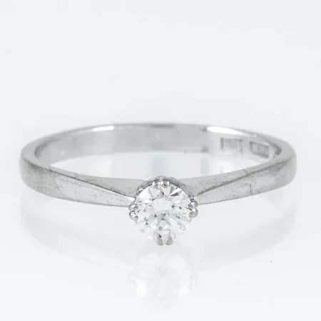 Ring i 18K vitguld med 1 x 0,28ct briljantslipad diamant. Den är i storlek 18¼, är 2 - 5 mm bred och väger 2,8g. Stämplad Z9, AGB, 18K & kattfot.