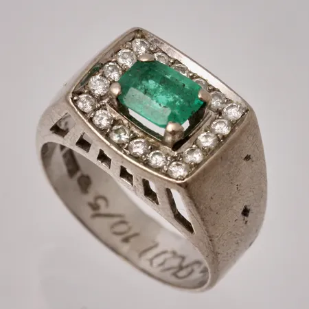 Ring i 18K vitguld, stl15¾, bredd 4,4-10,2mm, 1st Smaragd, mått 4,8x6mm, 18st Diamanter, mått Ø1,3mm, personlig gravyr, vikt 6,08g.