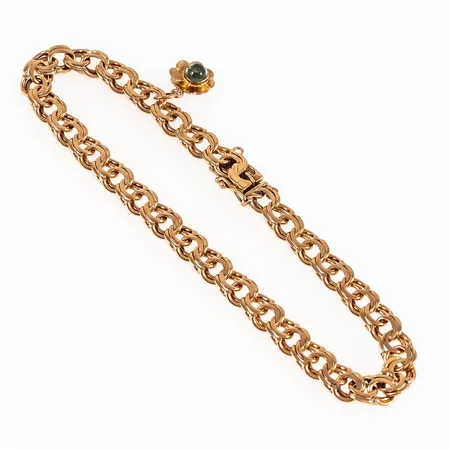 Armband, Bismarck i 18K guld: En berlock med grön sten. Det är 20,5cm långt, 6 mm brett och väger 12,9g. Kistlås. Öglor för säkerhetskedja finns. 18K & kattfot.