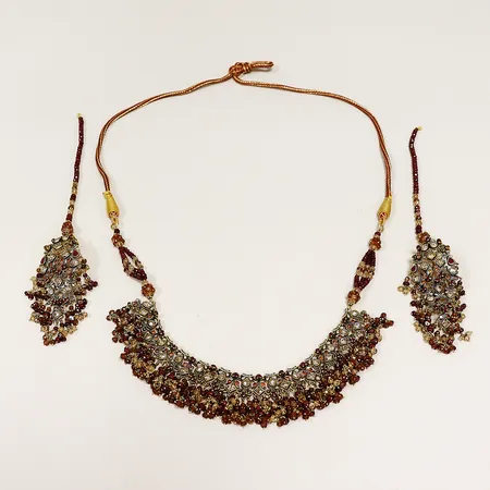 Collier med stenar, skevheter, längd inklusive tygbandet ca 74cm, ett par örhängen med stenar, skevheter, längd inklusive hårdekoration ca 20cm, 22K, bruttovikt 174,2gram.  Vikt: 174,2 g