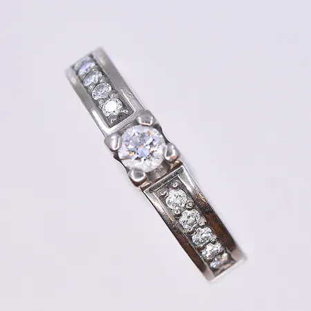 Ring med diamanter 1x0,20ct och 10x0,02ct, Schalins, stl 17¾, bredd 4 mm, graverad, vitguld,18K. Vikt: 6,6 g