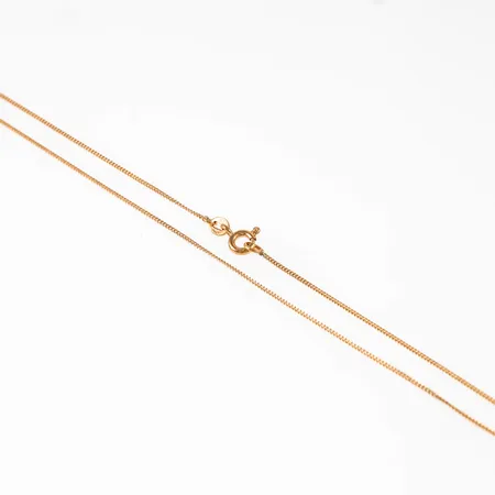 Kedja, tunn Pansar i 18K guld. Den är 36,5 cm lång, 0,85 mm bred och väger 1,4g. Springring. 