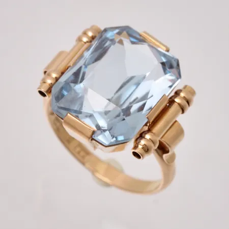 Ring i 18K guld, stl18, bredd 2,5-17,3mm, 1st blå sten, mått 12,7x15,8mm, bruttovikt 8,11g, ca nettovikt 4g.