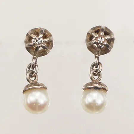 Ett par örhängen med diamanter 2x ca 0,02ct och pärlor, längd 14mm, bredd 4,6mm, vitguld, snurrebussar saknas, ostämplade, 18K  Vikt: 1,3 g