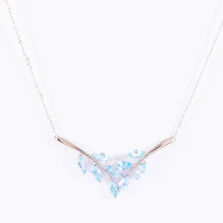 Collier i 18K vitguld: Integrerat hänge med blå topaser. Den är 42/45 cm lång. Hängets mått 34,5 x 17,5 mm. Vikt: 3,0g. Fint skick. Springring. (Guldfynd)