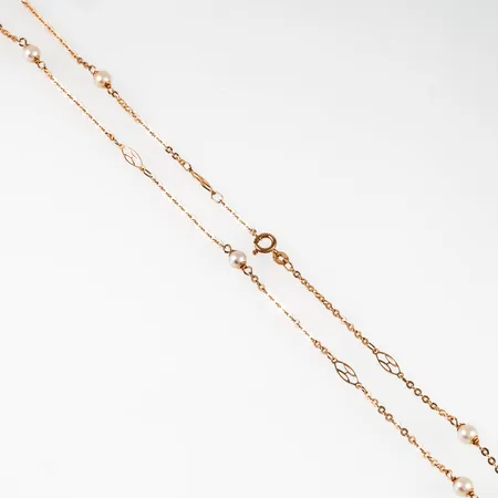Långt collier i 18K guld: Ankarkedja med länkar i genombrutet mönster och sju odlade vita pärlor Ø 5 mm. Det är 70 cm långt, 2 - 5 mm brett och väger 7,4g. Stämplad Uno-A-Erre, 750 & svensk importstämpel. Springring.