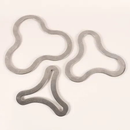 Tredelad uppsättning grytunderlägg, Terence Conran (1931-2020), rostfritt stål, 2000-tal. 