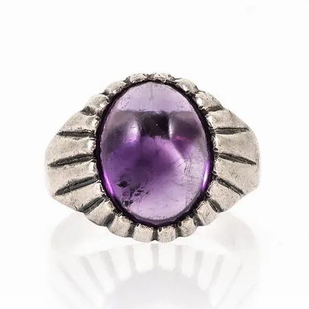 Ring i silver (835/1000) med en cabochonslipad ametist (13 x 10 mm), färgzoneringar. Den är i storlek 17¼, är 3,5 - 15 mm bred och väger 5,9g. Sten något lös. 