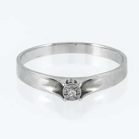 Ring i vitt guld 18K med en diamant ca 0,01ct. Den är 2,1 - 3,4 mm bred, är i storlek 18 och väger 1,8g. 