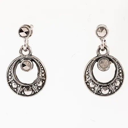 Hängande örhängen i silver (835/1000) med markasiter. De är 2,5 - 9 mm breda, 15,5 mm långa och väger 1,5g.