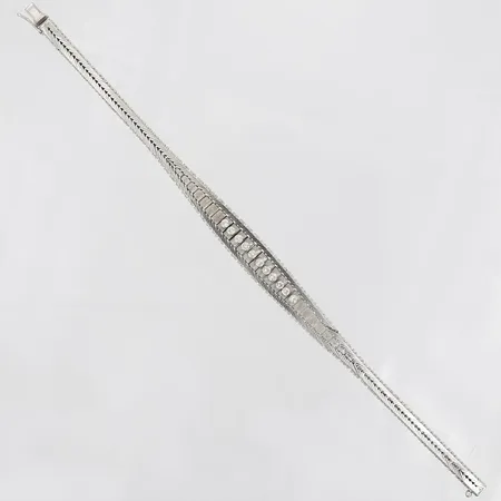 Armband i doserad stel modell med vit stenar, längd 19½cm, bredd 4 - 10mm, 18K vitguld. Vikt: 25,5 g