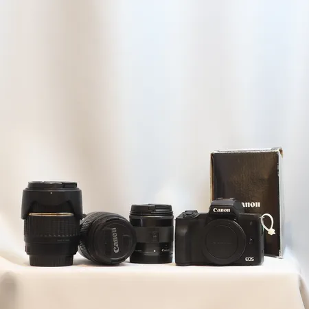 Spegellös systemkamera Canon EOS M50, med objektiv Canon EFM 11-22mm f/4-5.56 IS STM, samt två äldre objektiv med EF-fattning, EFS 18-55mmf/3.5-5.6 IS, Tamron AF 18-200mm f/3.5-6.3 (IF) Macro med motljusskydd, med Viltrox adapter EF-EOS M, ett batteri, laddare ej original, minneskort SanDisk Extreme PRO 128gb 170mb/s, med box till kamerahus (saknar kitobjektiv) och box till EFM 11-22mm, kamerahus med bruksslitage, velcrotejp, gummilucka på ena sidan saknas, EFM 11-22mm med bruksslitage, äldre objektiv med påtagligt bruksslitage, funktionstestad och till synes fungerande